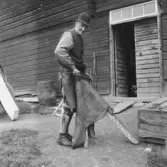 Leksand. Yttermo. Nygårds Anders vid falsbocken*

*En falsbock är ett traditionellt verktyg som främst används inom garvning och läderslöjd (skavning och tunnare av hudar) eller bokbinderi (för att vika och jämna till papper).

Källa: Wikipedia