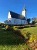 Hälsingtuna kyrka sedd från nordöst, till höger skymtar sockenstugan.