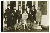 Möhippa år 1929. Blivande bruden Fanny Olsson (född Andersson) sitter i mitten omgiven av väninnor klädda i herrkläder.
Fanny (1882-1970) gifte sig den 19 maj 1929 med Olof Olsson (1895-1970) i Stockholm.

Fotografiet är bilaga till föremål NM.0317986 - Observera att det ej är samma klänning Fanny bär på detta fotografi.