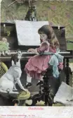 Brevkort med motiv av flicka som spelar piano framför hund, med bildtexten 
