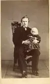 Porträtt av en man med ett barn i knät, 1866 (enligt text baksida kort).