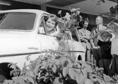 Prisutdelning i Nescafétävlingen vid Snabbköpshallen på Estö, Hamnviksvägen 24. Första pristagaren Karin Lindström sitter i bilen som var första priset, en Volvo Amazon 121 herrgårdsvagn. Prisutdelning i slogantävling arrangerad av Findus 2/7 1964. 

Källa: Nynäshamns Posten 7 juli 1964. 