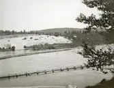 Byggandet av Älvkarleby kraftverk med flottningsränna som användes för att torrlägga delar av forsen under byggnadstiden, omkring år 1906 (enligt text i album).