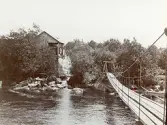 Byggandet av Älvkarleby kraftverk, där tillfälliga mindre hängbroar uppfördes för att arbetare skulle kunna ta sig fram innan de permanenta broarna var klara, omkring år 1906 (enligt text i album).