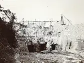 Byggandet av Älvkarleby kraftverk med träkonstruktioner som restes för att tämja de kraftiga Älvkarlebyfallen och bereda plats för maskinsalen, omkring år 1906 (enligt text i album).