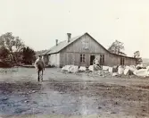 Arbetare utanför en arbetarbostad i Älvkarleby, vid byggandet av Älvkarleby kraftverk, omkring 1906 (enligt text i album).