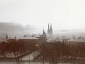Vy över Uppsala med Domkyrkan i bakgrunden bakom molnen, omkring 1906 (enligt text i album).