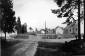 Bebyggelse utmed Halmstadsvägen i Hyltebruk. Villor omgivna av träd. En bil kommer körande på grusvägen.