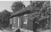 Bostadshus i Släps kyrkoby, inåt vägen till Gröna Bur. En stentrappa leder upp till ingången med tvåbladig dörr och överljus.