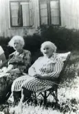 Systrarna Dagmar och Signe Hansson sitter i trädgården, Guntofta 1:4 Släp.