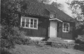 Bostadshus, övre byggnaden, Algusered, Släp. Över entrén sitter ett skärmtak och däröver en liten takkupa.