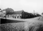 Korsningen Kyrkogatan-Östra Långgatan, kv Apotekare i Varberg. Kyrkan ses längre nedåt Kyrkogatan. Bilden tagen mot väster. Till vänster i bild syns skylt: 