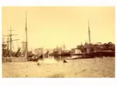 Bild från Varbergs hamn på 1880-talet. I bakgrunden ses magasin, tullhus, varmbadhus och fästning.
