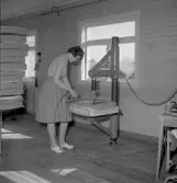 Kvinna vid tapetseraremaskin