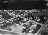 Flygfoto över Oskarström. Villakvarter utmed korsande vägar. Förlag: Carl-Oscars Cigarr- & Pappershandel, Oskarström.