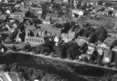 Flygfoto över Falkenbergs centrum. I nederkant rinner Ätran, där Grand hotell ligger till vänster. Bakom det ses Rådhuset vid Rådhustorget och uppe till höger ses Stortorget. Förlag: Forssells Pappershandel, Falkenberg.