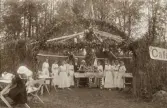 En välgörenhetsfest utomhus, möjl. i Alvesta. Några kvinnor och två herrar har anordnat ett 