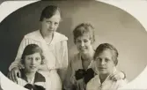 Några tonårsflickor (klasskamrater?) i ljusa klänningar har samlats hos fotografen.
Till vänster (i mörk krage) syns Ruth Svensson, Alvesta.