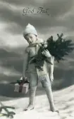 Julkort med motiv av pojke med vinterkläder och jultema. Text på baksidan, adresserat Ellen Sundberg.