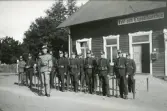 Trol. Yngve Svensson som gruppbefäl (i m/10) med en grupp soldater, framför vakt- och expeditionshuset på Kronobergshed.