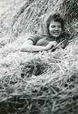 Gunnel Persson Hultin vilar i höet, 1944 (enligt text i album). Text baksida kort: 