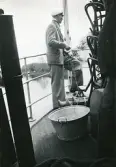 Man i kostym och skärmmössa ombord en båt. Sjömanöver 1946. Text i album: 