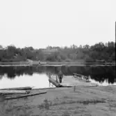 Gagnef. Åkerängsta färja och färjkarlen Karl Hedlund. Gårdar i Mjälgen på andra sidan älven. 1920.
