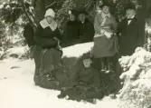 Ett sällskap bestående av tre män och tre kvinnor, tar en paus under en vinterpromenad.