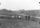 Vid trefaldighetskällan, Björk källa, utsikt mot Tidstrands yllefabrik. 
okänd, okänd,  Anna Åhl och Albin, Kerstin Björkblom, Anders Björkblom och Eric Karlsson.