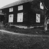 Vy, Jugansbo. Boens (nu Sandbergs) gamla stuga (skall rivas). Blybågar i vindsfönstret närmast knuten. 1931.