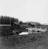 By, Fullsta. Tunnvälvd stenbro över Lindbäcken(Norrbro bäcken). Smedja och bastu på andra sidan. 1931.