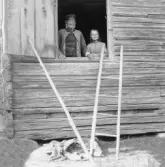 Gagnef. Förre soldaten Johan Sundell med gumma i loggluggen, By. 1920.
