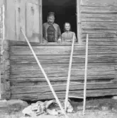 Gagnef. Förre soldaten Johan Sundell med gumma i loggluggen, By. 1920.